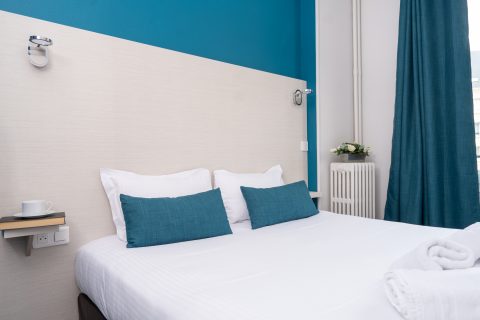 chambre double confort bleue et blanche vue sur le haut du lit